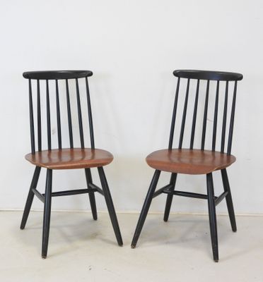 pair of black and wood chairs against a white wall