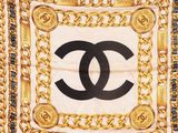 a chanel scarf with gold chains and a black and white logo