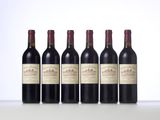 four bottles of wine are lined up on a table