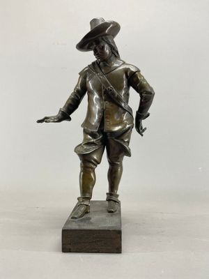 statue en bronze représentant un homme coiffé d'un chapeau, posée sur un socle en bois