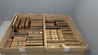 des boîtes de livres sont empilées dans une pièce