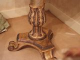 a gold pedestal with a vase on top of it