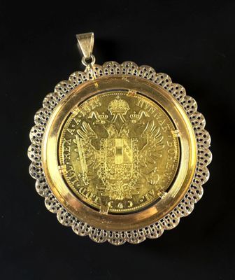 a close up of a gold coin on a black surface