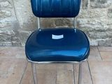 a blue chair that is sitting on a tile floor