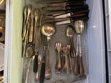 une boîte blanche remplie d'argenterie et de cuillères en argent