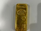 a close up of a gold bar on a white surface