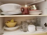 many dishes and cups on the shelves in the kitchen