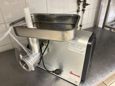 un hachoir à viande posé sur un plan de travail dans une cuisine
