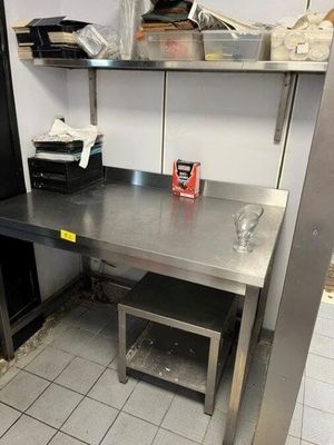 a kitchen with a table and a refrigerator in it