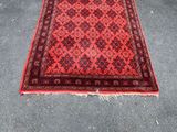 a red and black rug on the ground in a room