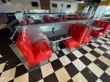 a checkered floor in a diner with red chairs