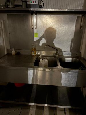 l'ombre d'une personne debout devant un évier de cuisine