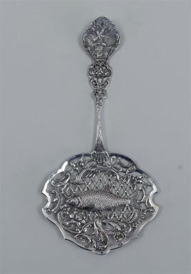 a close up of a spoon with a fish on it