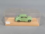 a green toy car in a clear box on a table