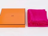 an orange box with a pink scarf sitting next to it