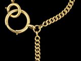un gros plan d'un bracelet en or orné d'une pierre rouge