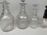 three glass bottles with a black top and a silver top