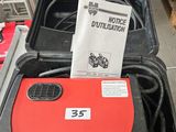 une photo d'une valise rouge et noire sur laquelle est apposée une étiquette