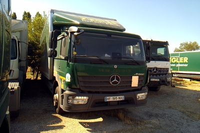 deux camions garés l'un à côté de l'autre sur la terre battue