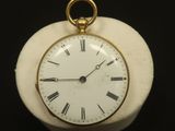 une petite horloge blanche avec des chiffres romains