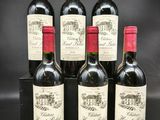 six bouteilles de vin rouge sont posées sur une surface noire