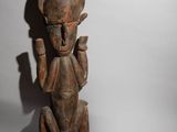 an old wooden statue of a man holding a knife in his hand