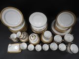 a lot of white and gold plates and bowls