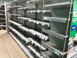 many empty shelves in a store with no one on them