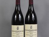 two bottles of wine sitting on top of a table next to each other