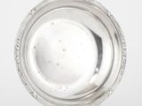 un plateau d'argent antique sur un support sur une surface blanche