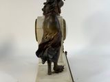 statue of a woman sitting on a chair with a deer on her back