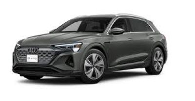 un SUV Audi e-trac gris de 2020 garé sur un fond blanc