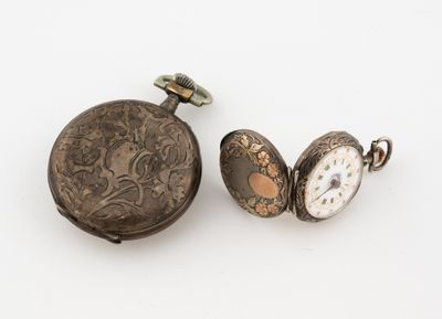 Deux montres de poche anciennes sont posées l'une à côté de l'autre sur une surface blanche