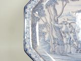 a blue and white plate with a painting on it