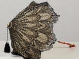 un parapluie en dentelle noire orné d'un pompon