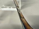 a silver spoon with a wooden handle on a table
