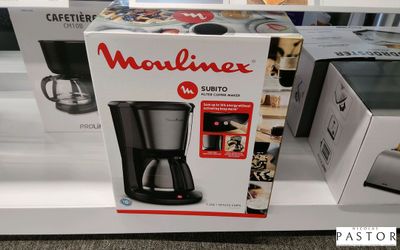une boîte sur laquelle est posée une cafetière, exposée en vitrine