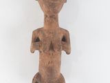 an old wooden figurine of a woman with a hat on her head