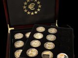 a wooden box with twelve gold coins in it on a black background