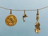 trois pendentifs en or suspendus à une cordelette, représentant un oiseau et une étoile