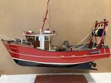 a model of a red boat on display on a table