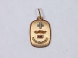 a close up of a small gold pendant with a cross on it
