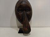 wooden sculpture of a man ' s face with a long nose