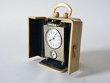 a small clock inside of a case on a white surface