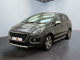La voiture grise est garée dans une grande pièce au sol noir.