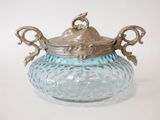 a blue glass jar with a silver lid on a table