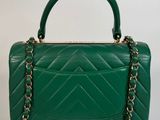 a green quilted handbag with a gold chain strap