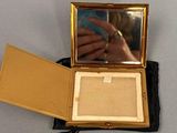 someone is taking a picture of themselves in a mirror in a gold case