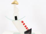 a glass sculpture of a man on a surfboard on a table