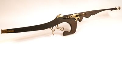 un vieux fusil exposé sur une surface blanche